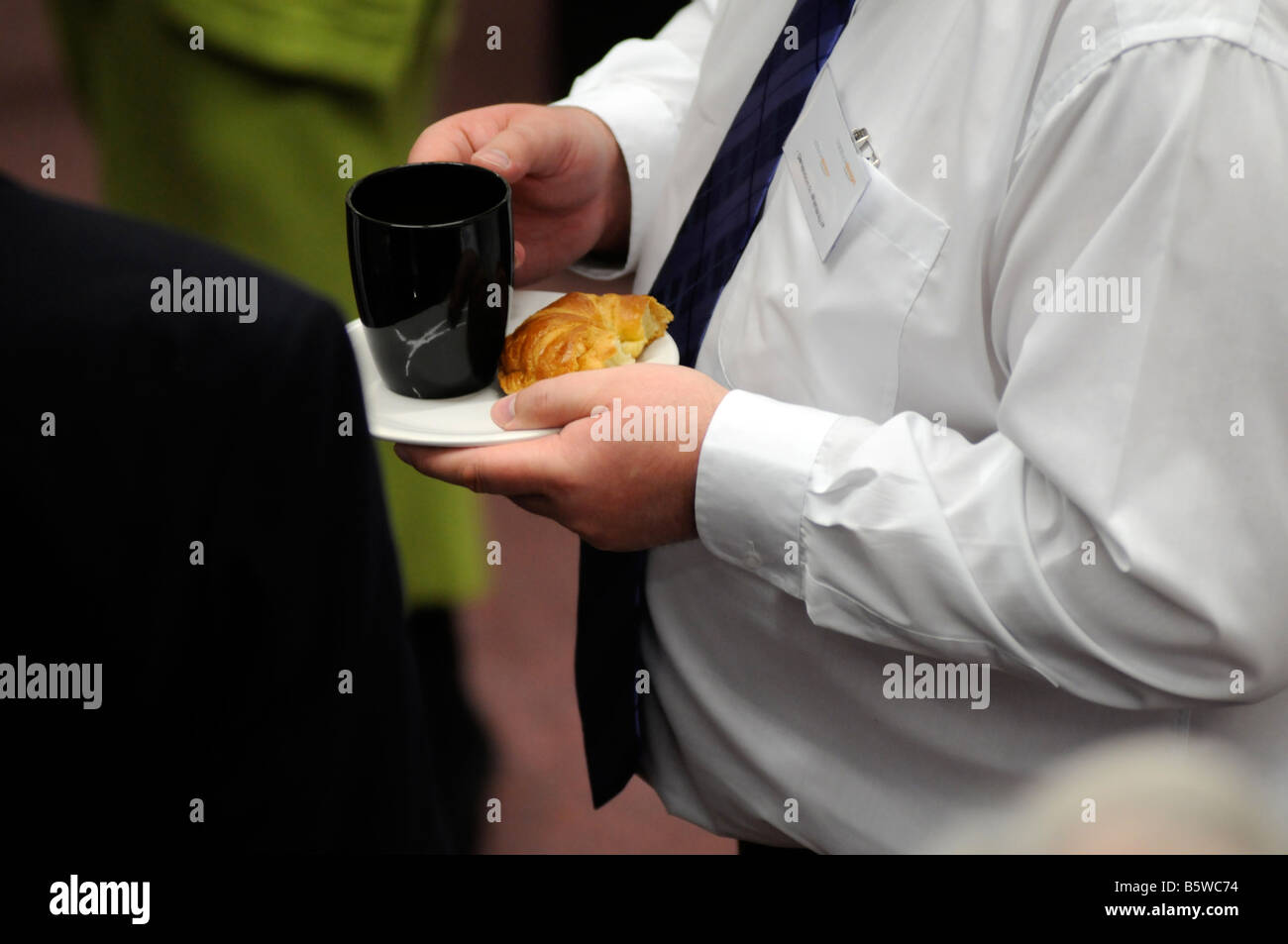 Royalty free photograph of overweight business man eating an unhealthy meal at a meeting in a hotel in London UK Stock Photo