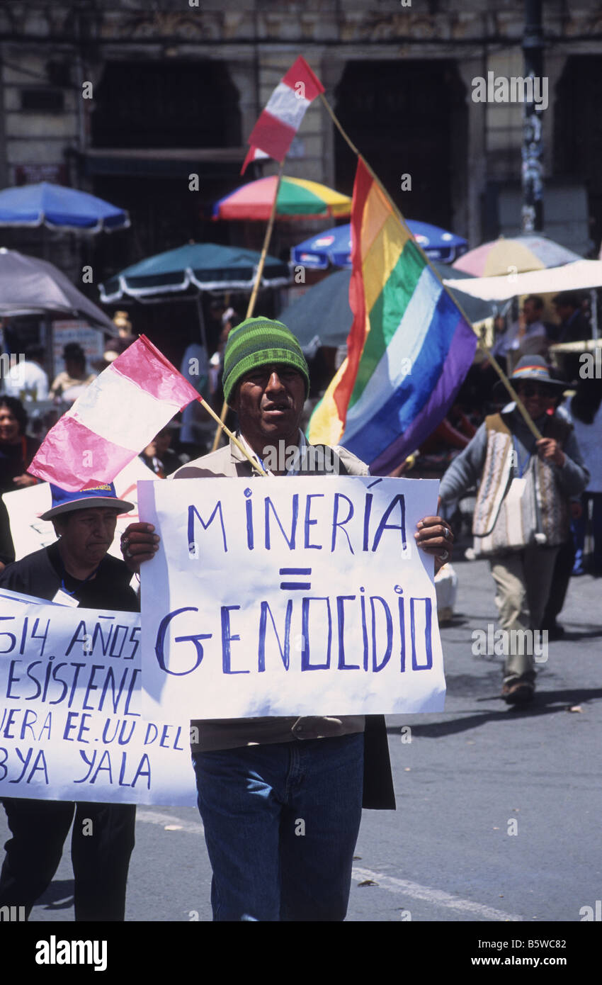 Indigenous protester with banner with 'Mining equals Genocide' written on it taking part in protest march, La Paz, Bolivia Stock Photo