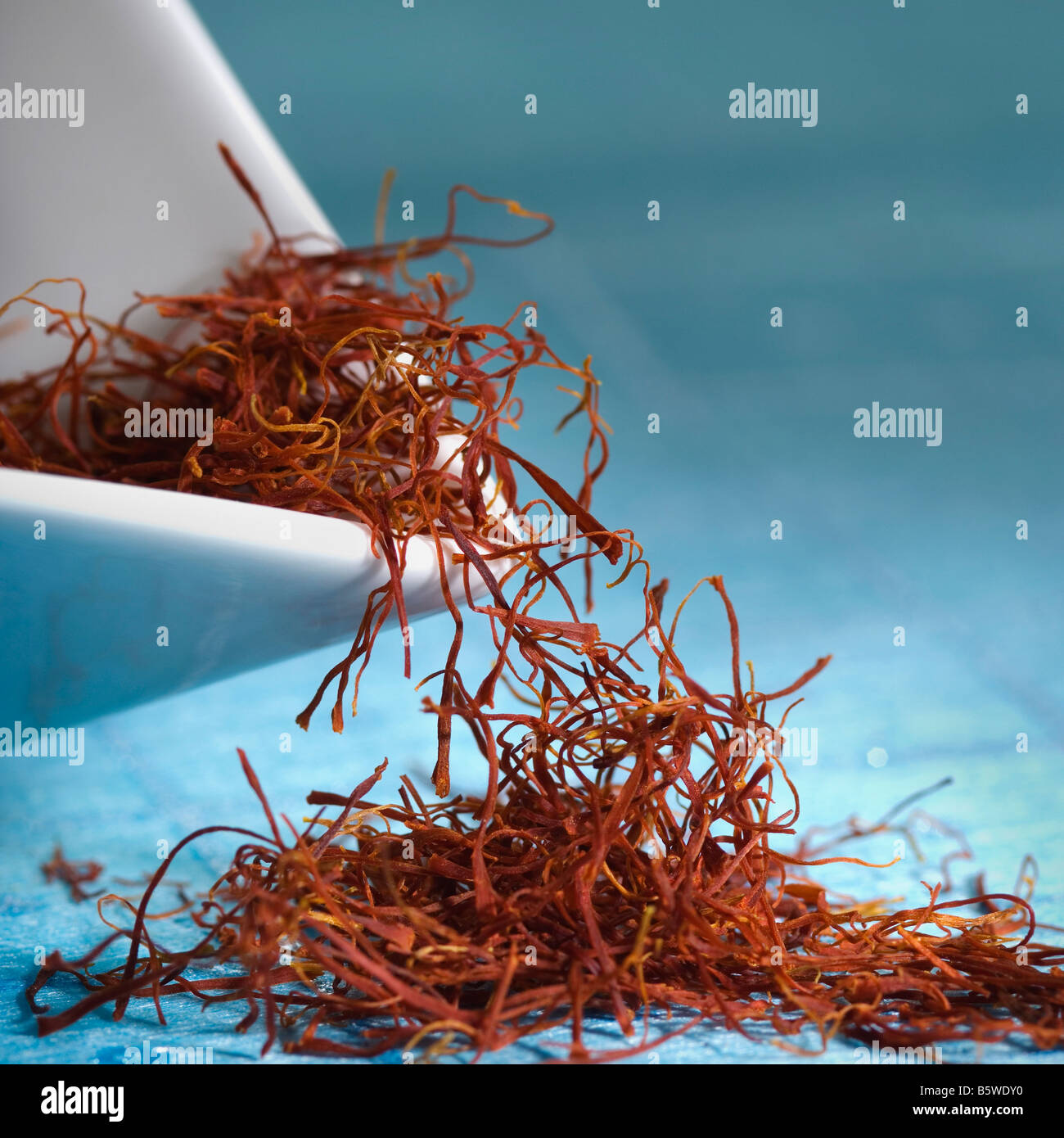 Saffron threads spilling from a bowl Stock Photo Alamy