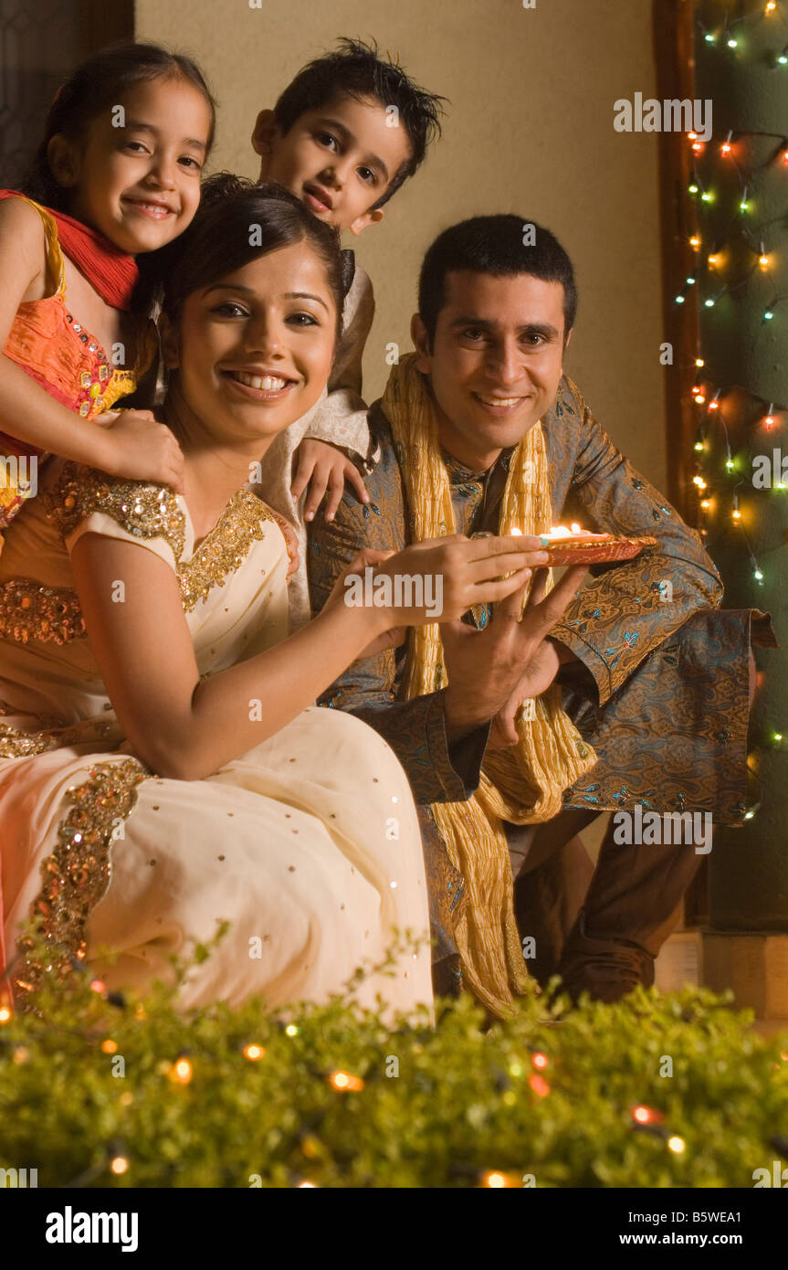 Couple holding religious offering with their children Stock Photo