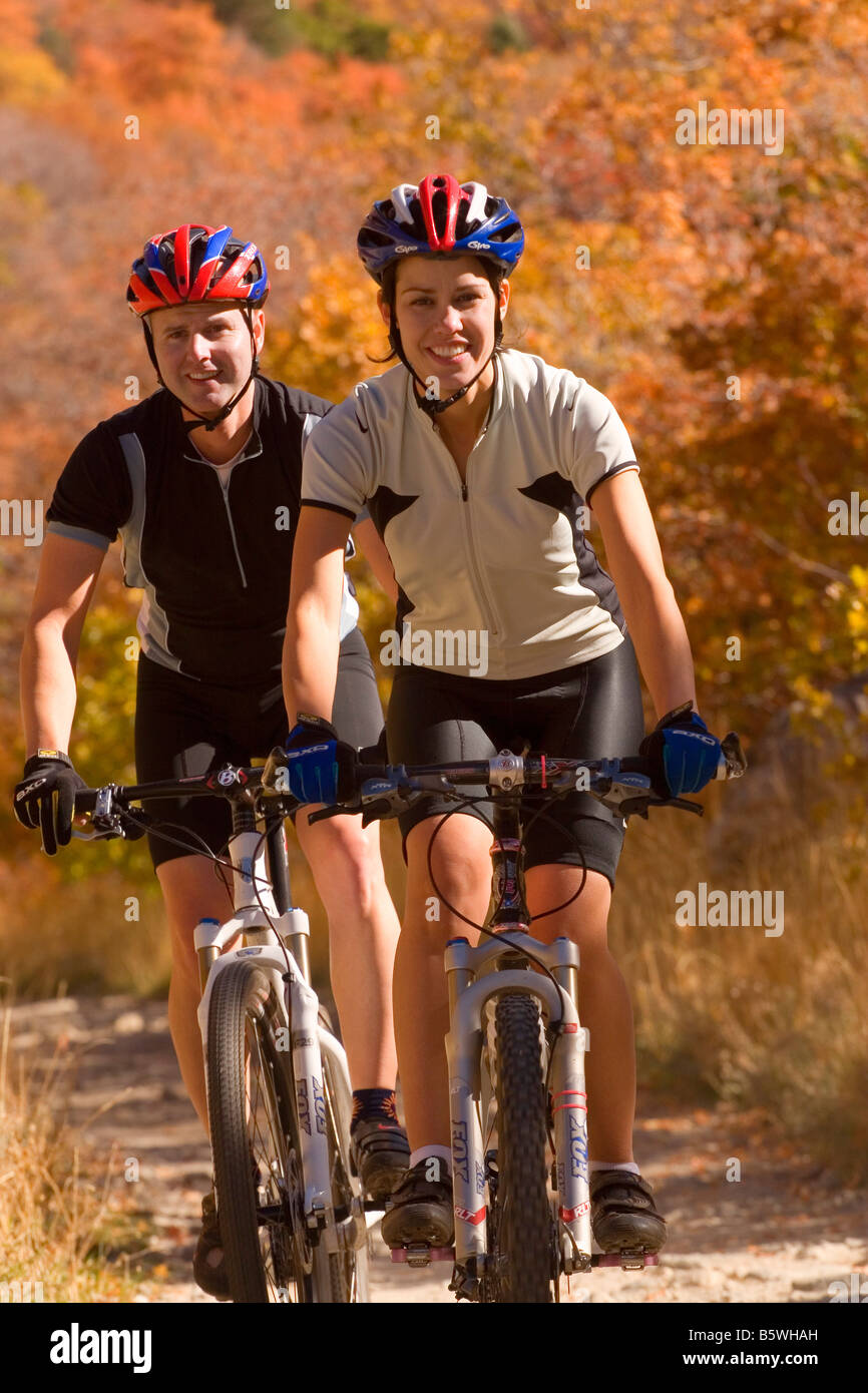 Young couple mountain biking riding amid the autumn colors on the