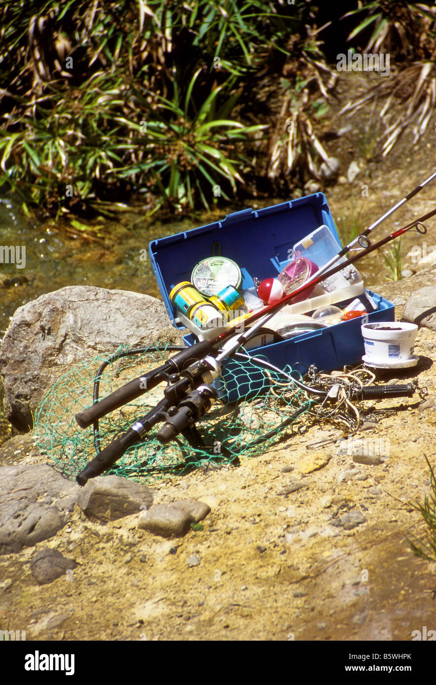 Fishing tackle and poles rest next to stream Stock Photo - Alamy