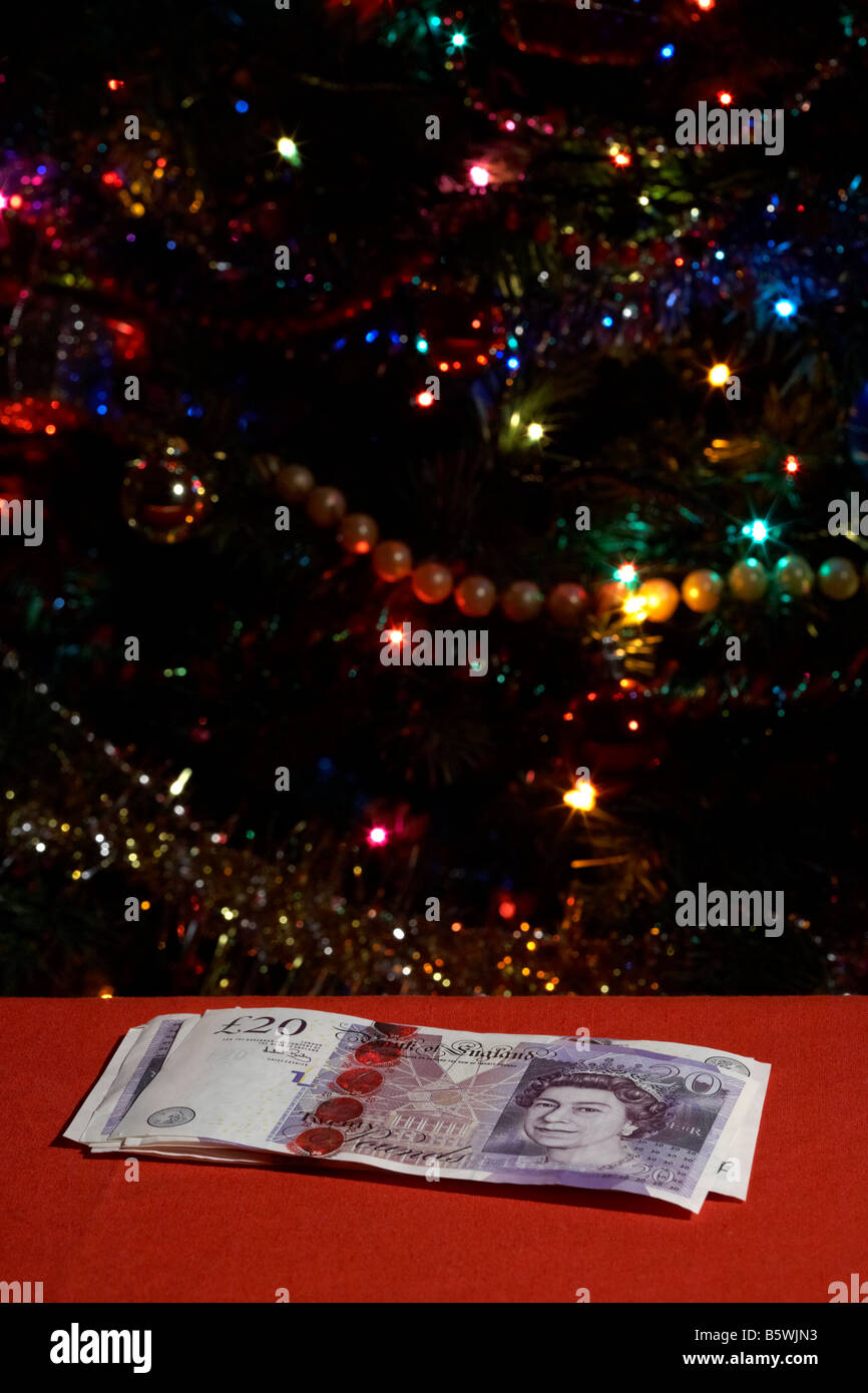 pile of twenty pounds sterling british pounds in front of christmas tree Stock Photo