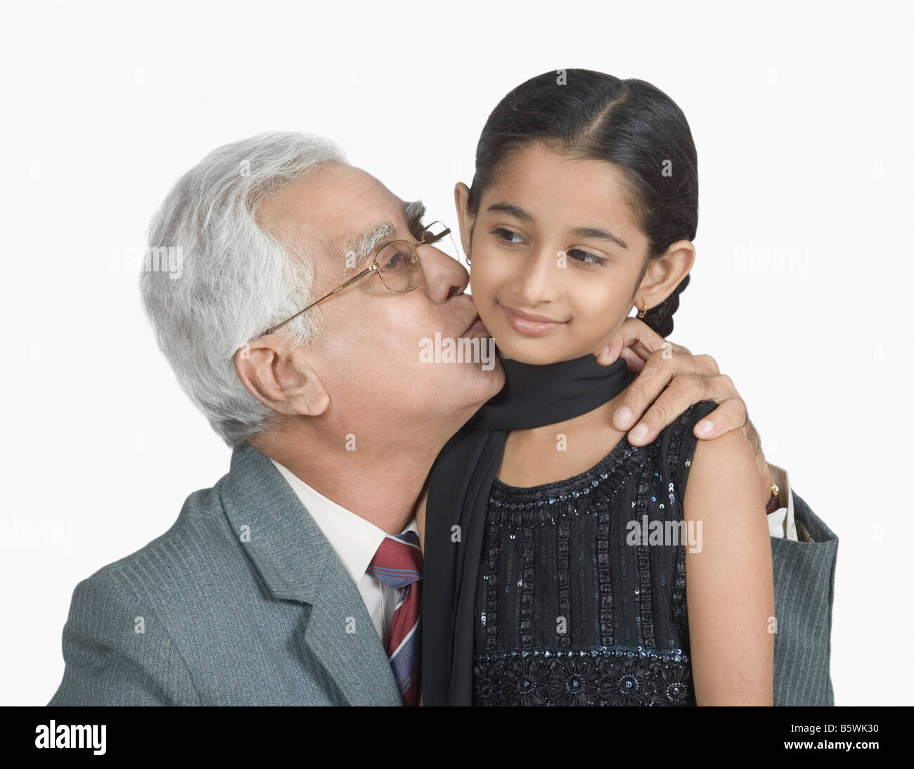 Close-up of a senior man kissing his granddaughter Stock Photo