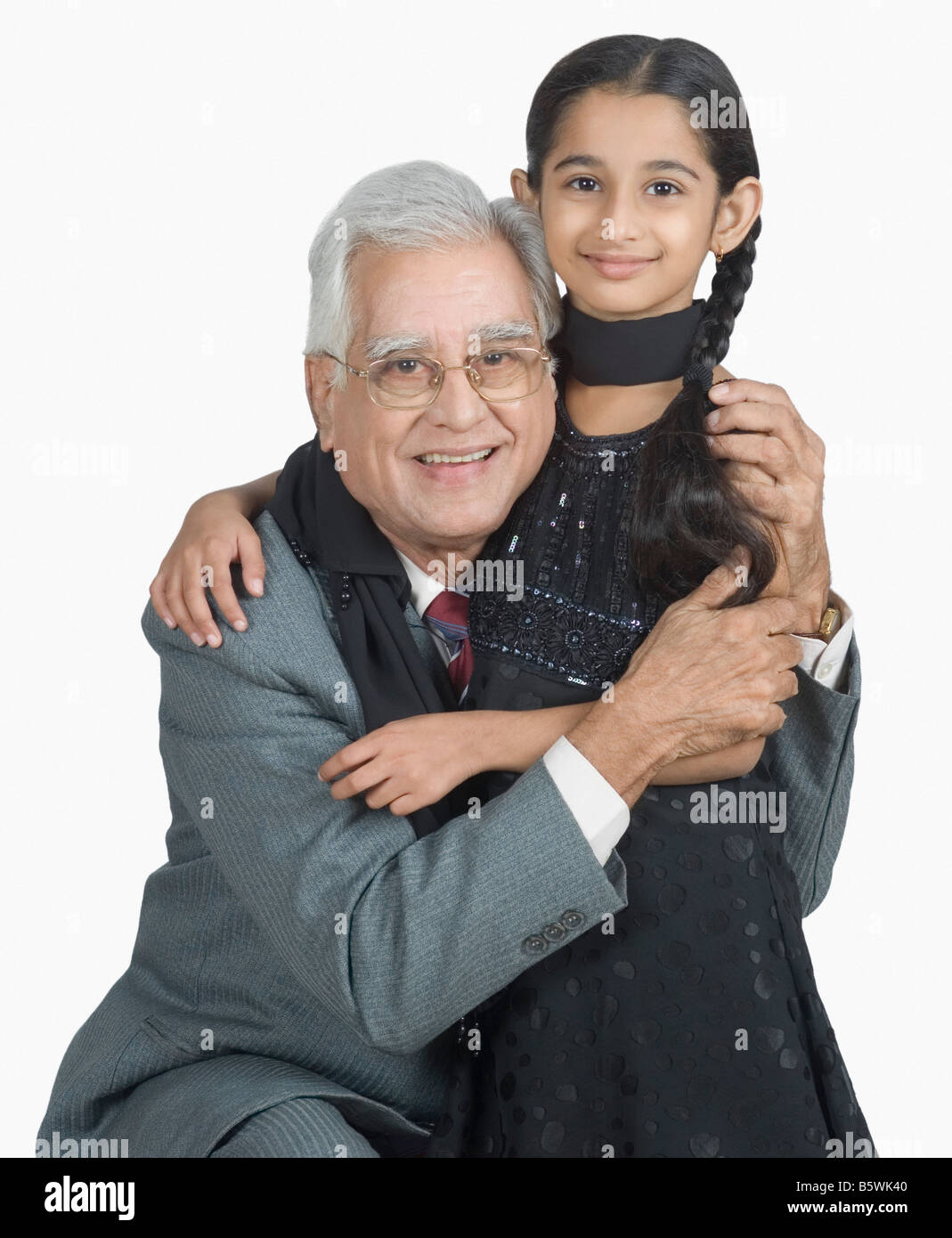 Senior man hugging his granddaughter and smiling Stock Photo