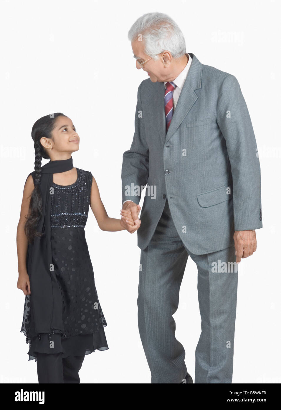 Senior man walking with his granddaughter Stock Photo