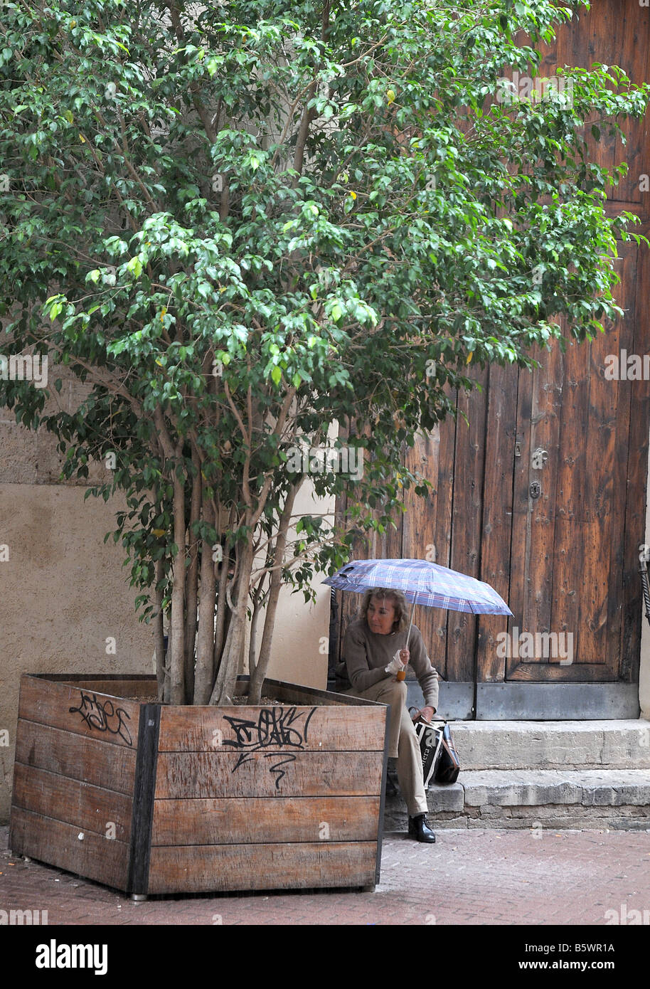 A woman shelters from summer rain in Palma, Mallorca. Stock Photo