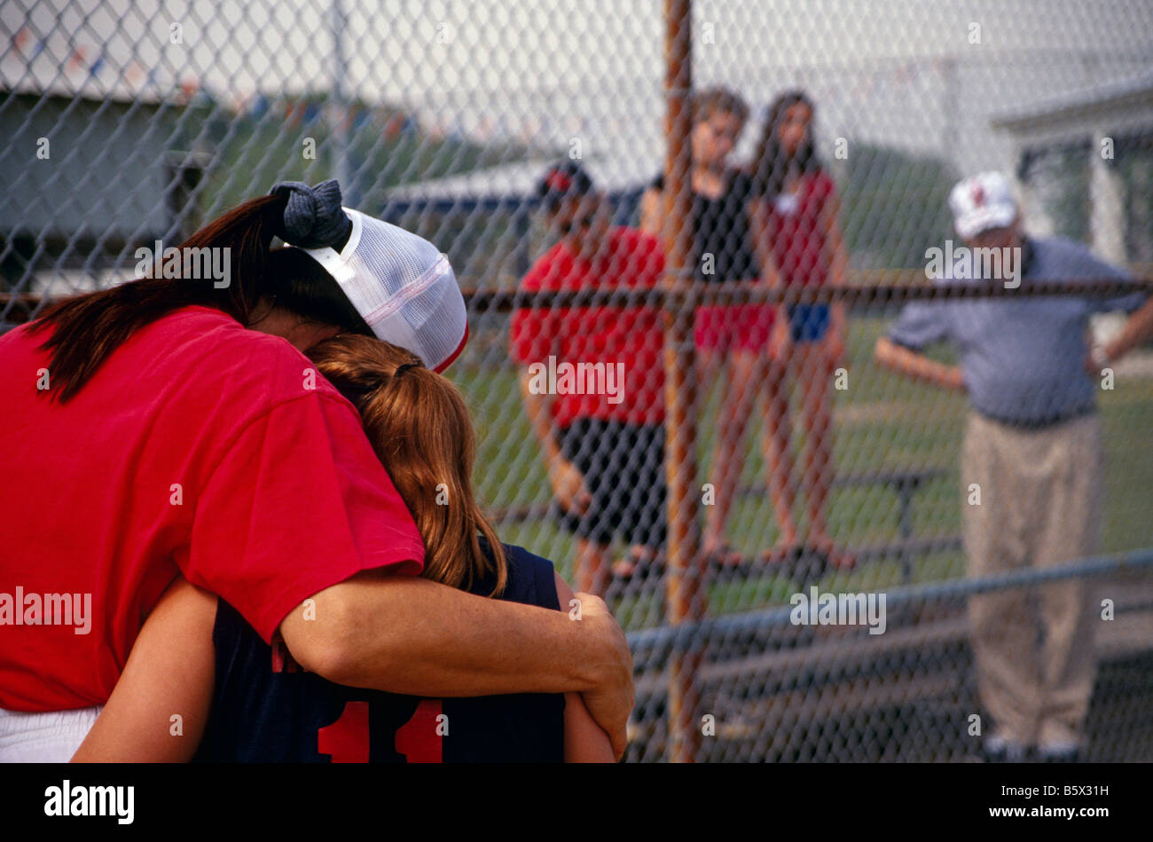 Coach comforting player girls softball Stock Photo Alamy