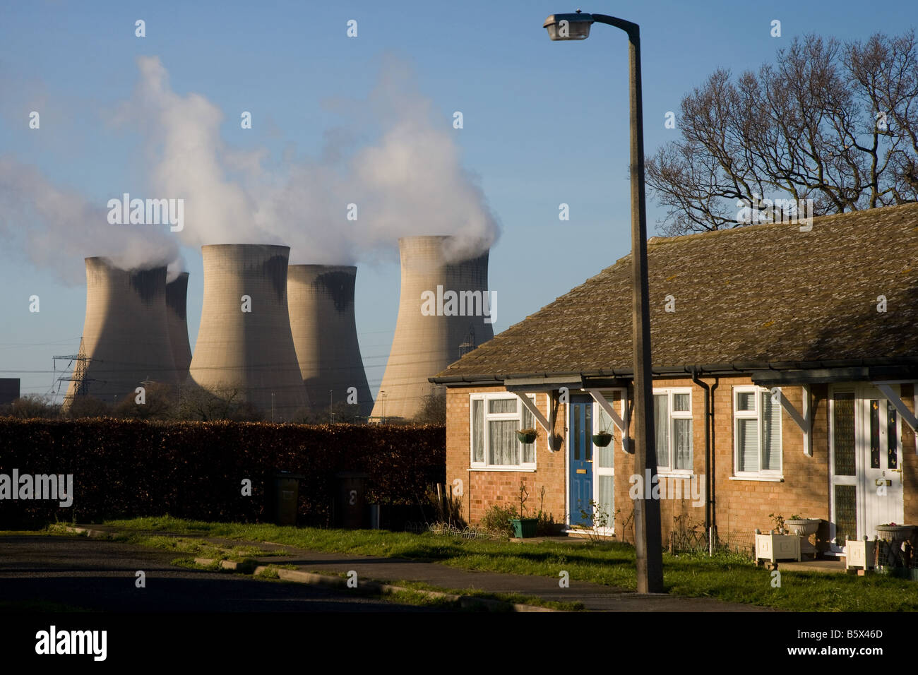 Drax Power Station - bungalows in urban housing estate overshadowed by high cooling towers - Selby, West Yorkshire, England, UK. Stock Photo