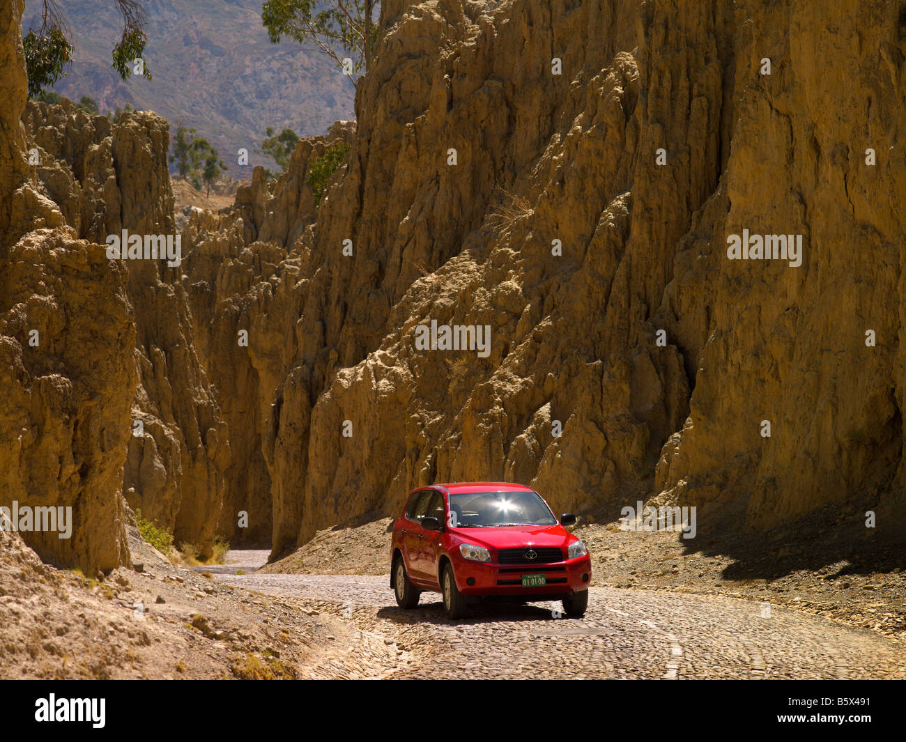 Red car winding road yellow rocky mountain trip touristic peak curve landscape horizontal 4x4 truck panoramic rout scenery view Stock Photo