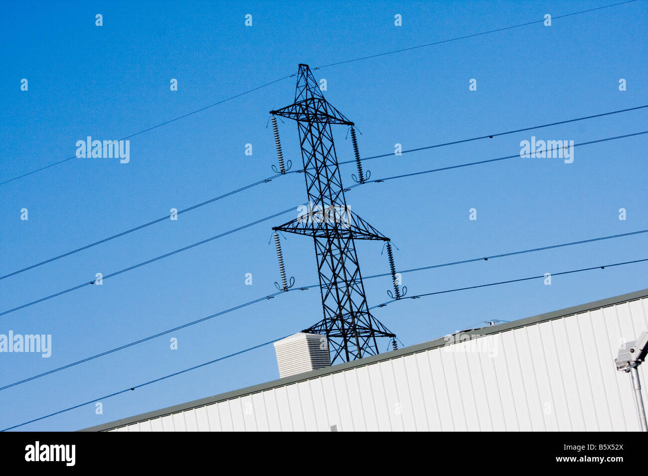 Electricity pylon against blue sky Stock Photo - Alamy