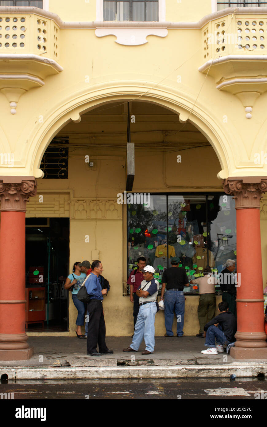 People chatting under the arches next to Parque Libertad in downtown San Salvador, El Salvador Stock Photo
