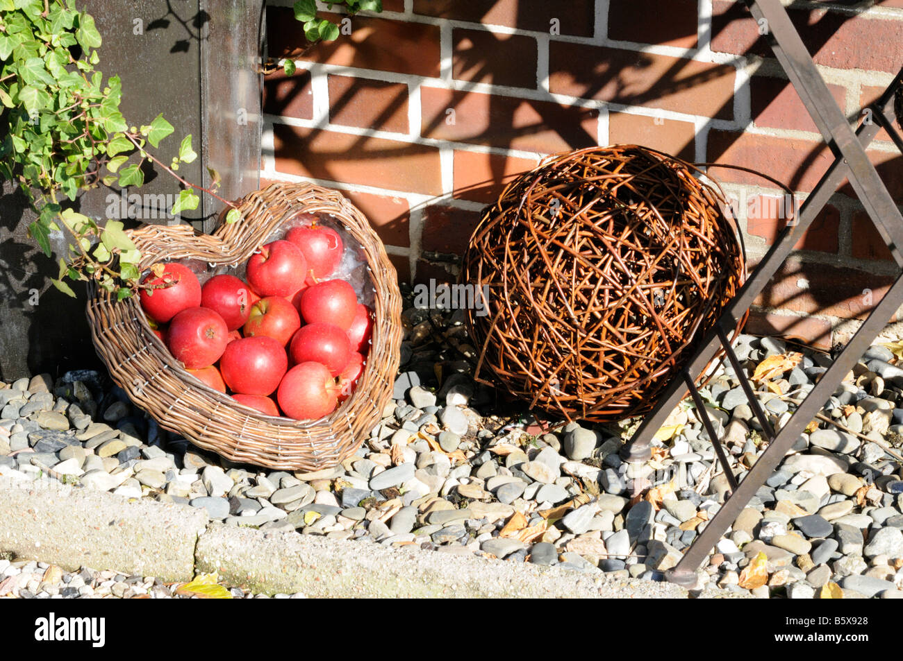 Gartendekoration mit Äpfeln und Korbwaren Garden decoration with apples and wickerwork Stock Photo