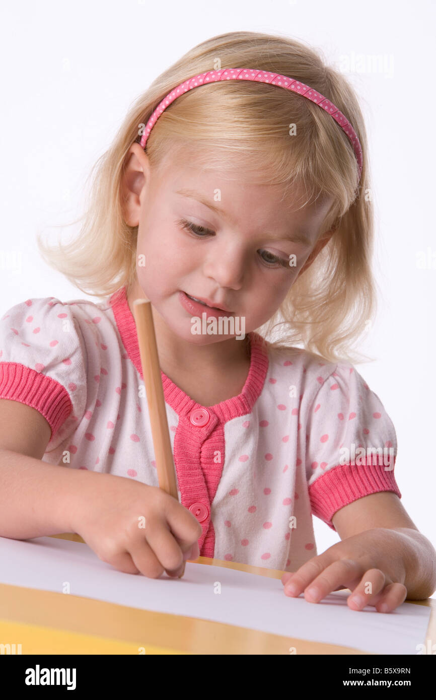 Little blond girl with a coloring pencil Stock Photo - Alamy