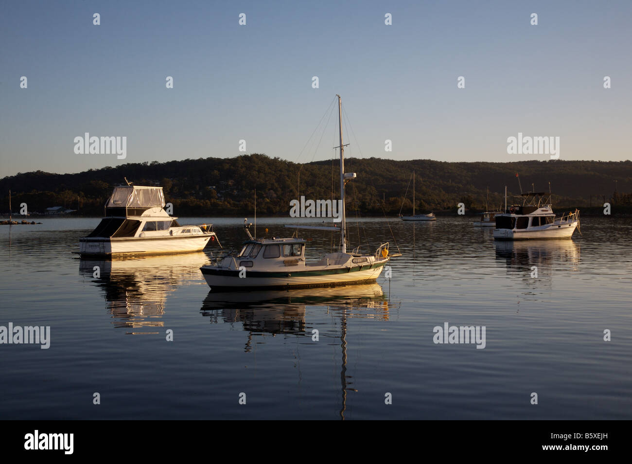 Boats moored on Brisbane Water, looking across the bay from Gosford to Tascot, NSW Australia Stock Photo