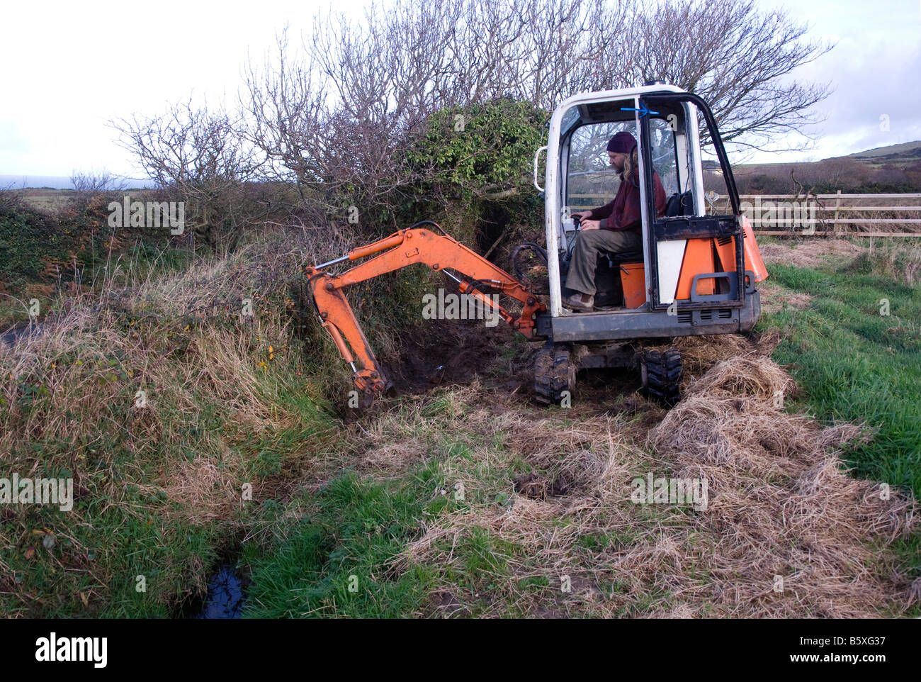 Simon Buttimore digging out ditch with a mini digger in the Isle of Man