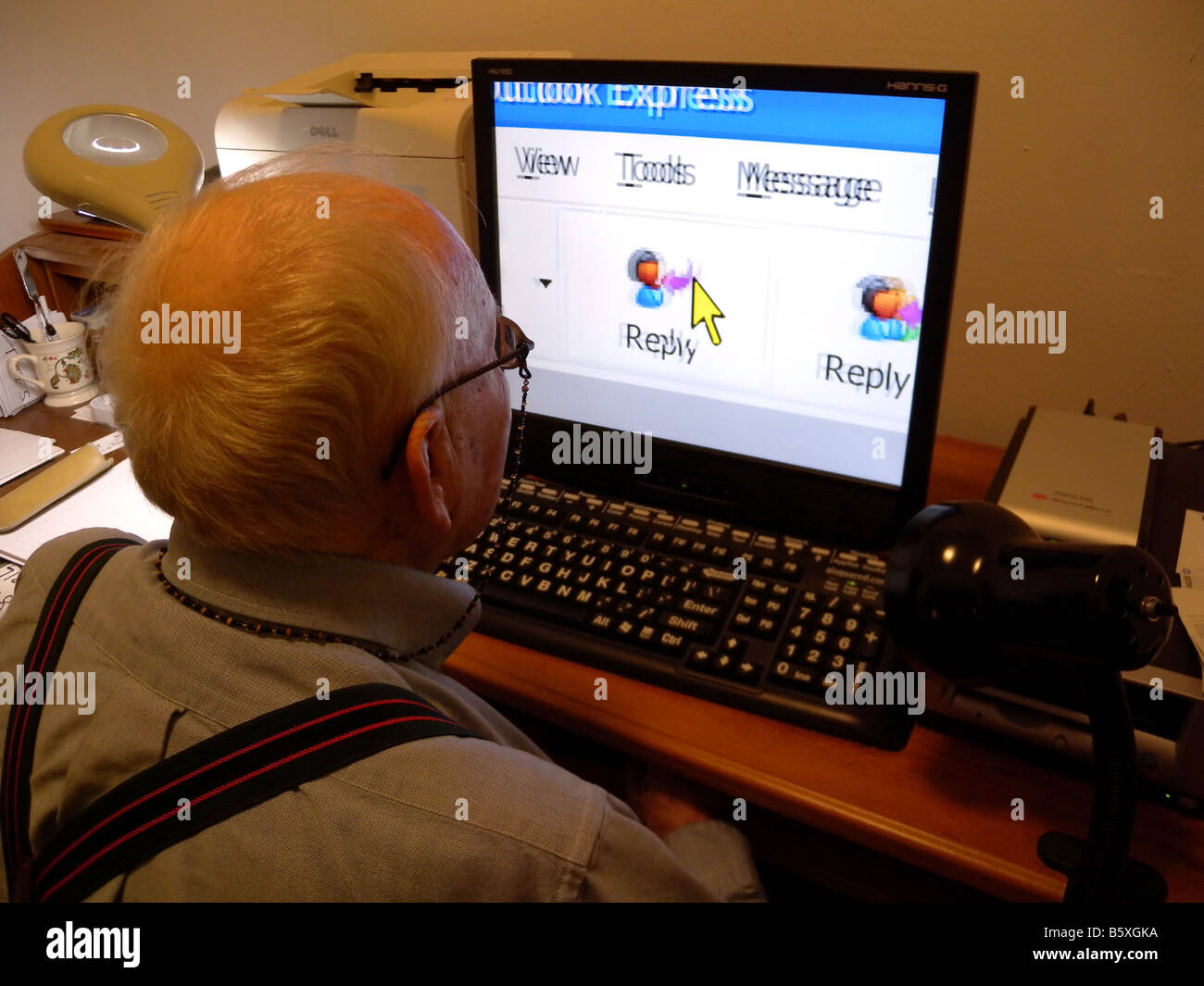 A senior citizen uses a computer equipped with screen enlargement