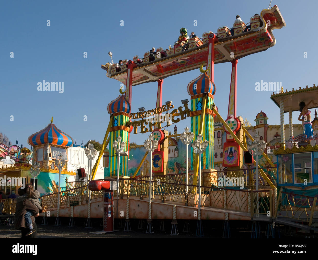 fair with racing amusement rides in different colours flying carpet
