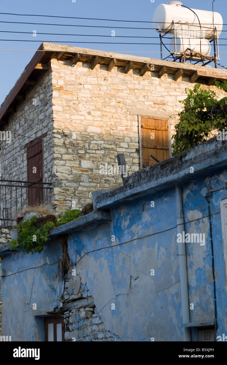 Old blue colored house wall with water tank on roof Stock Photo