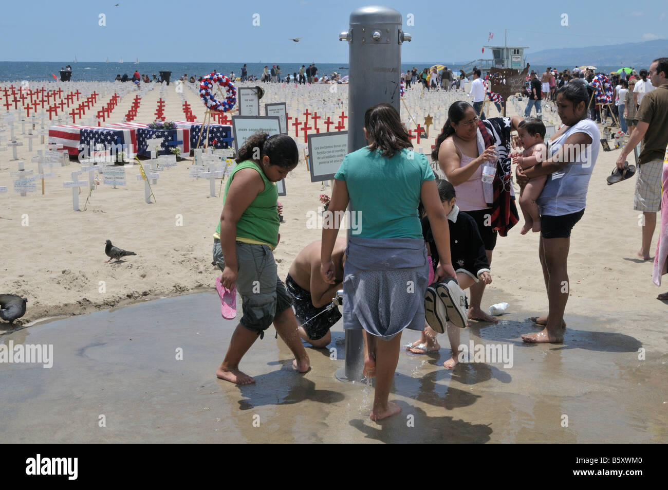 Group of people washing their feet around shower on the beach at Santa
