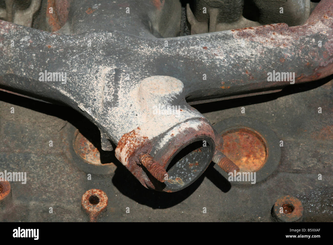 Automobile engine detail showing exhaust manifold to exhaust pipe