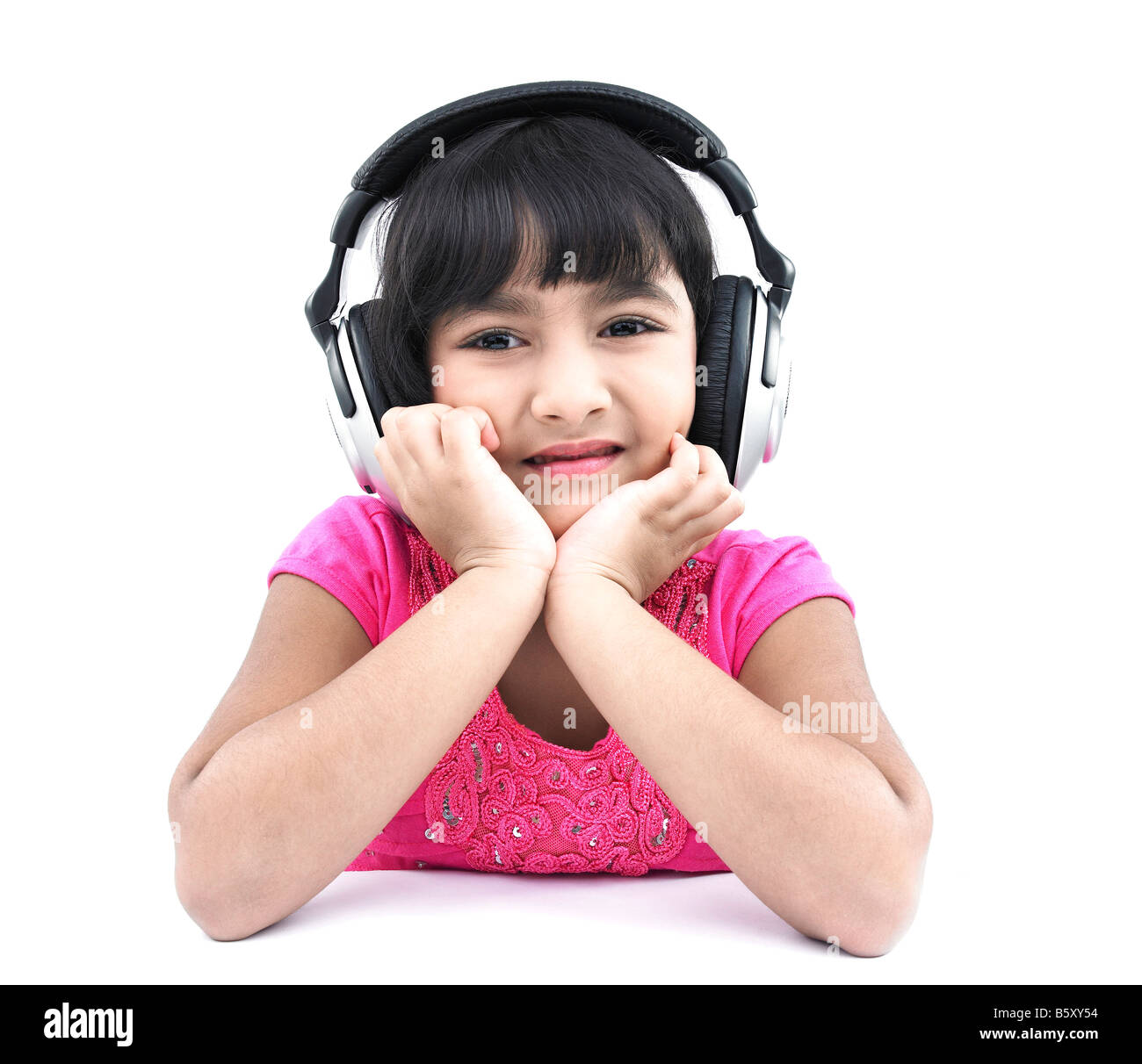 a pretty looking asian girl of indian origin listening to music Stock Photo