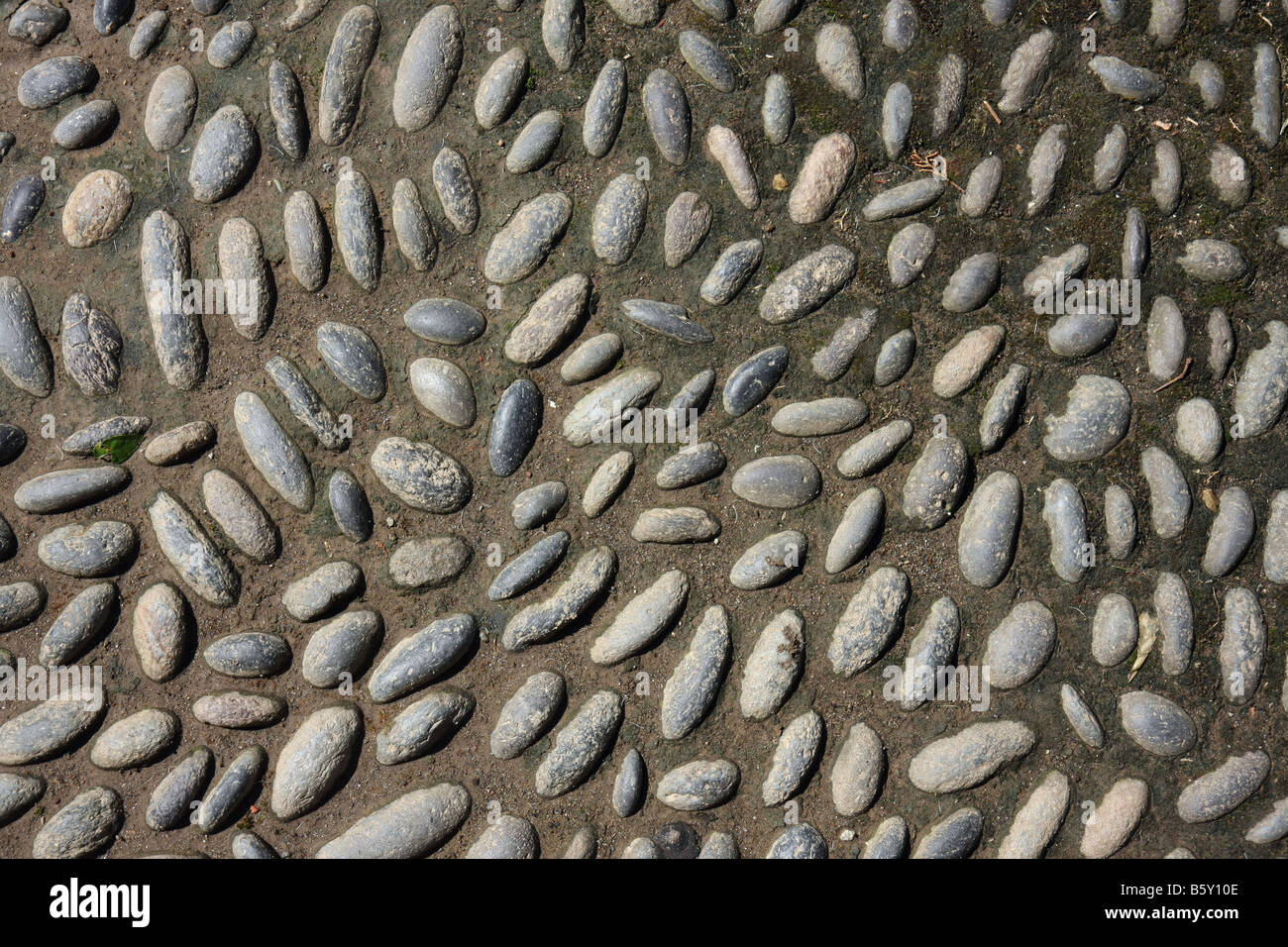 Small oval stones as paving stones on a walking path Stock Photo