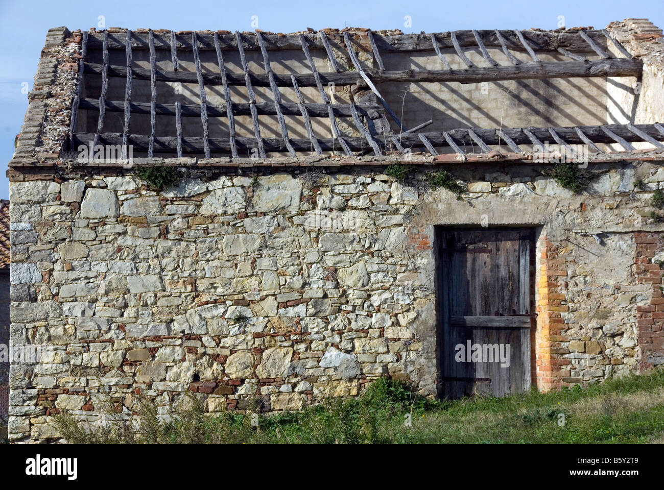 Abandoned stone farmhouse with the rafters showing, Tuscany Italy Stock Photo