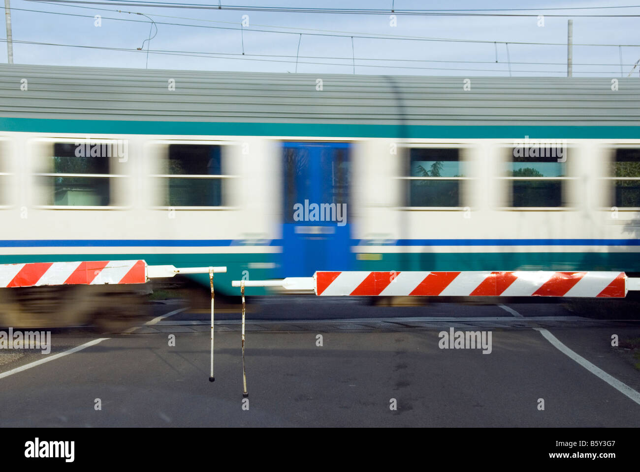 Italian passenger train at level crossing Stock Photo