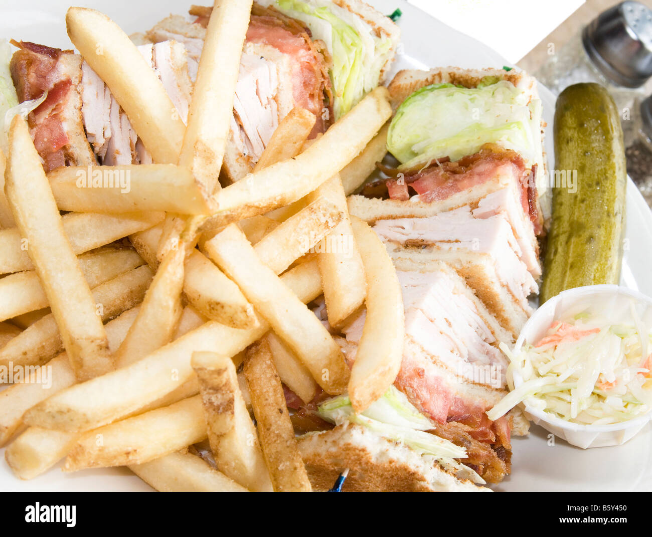 turkey club sandwich triple decker with french fries cola pickle Stock