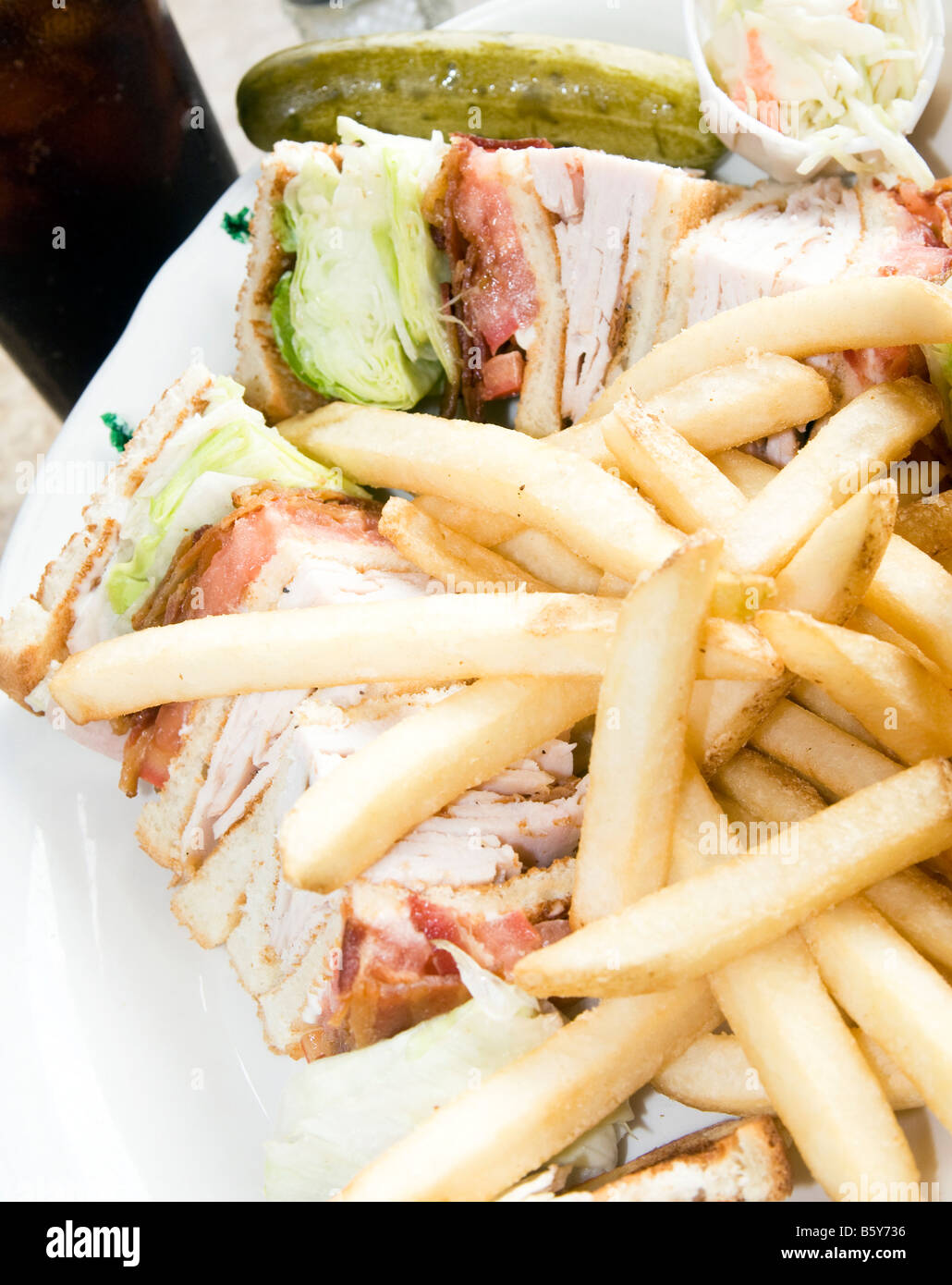 turkey club sandwich triple decker with french fries cola pickle Stock