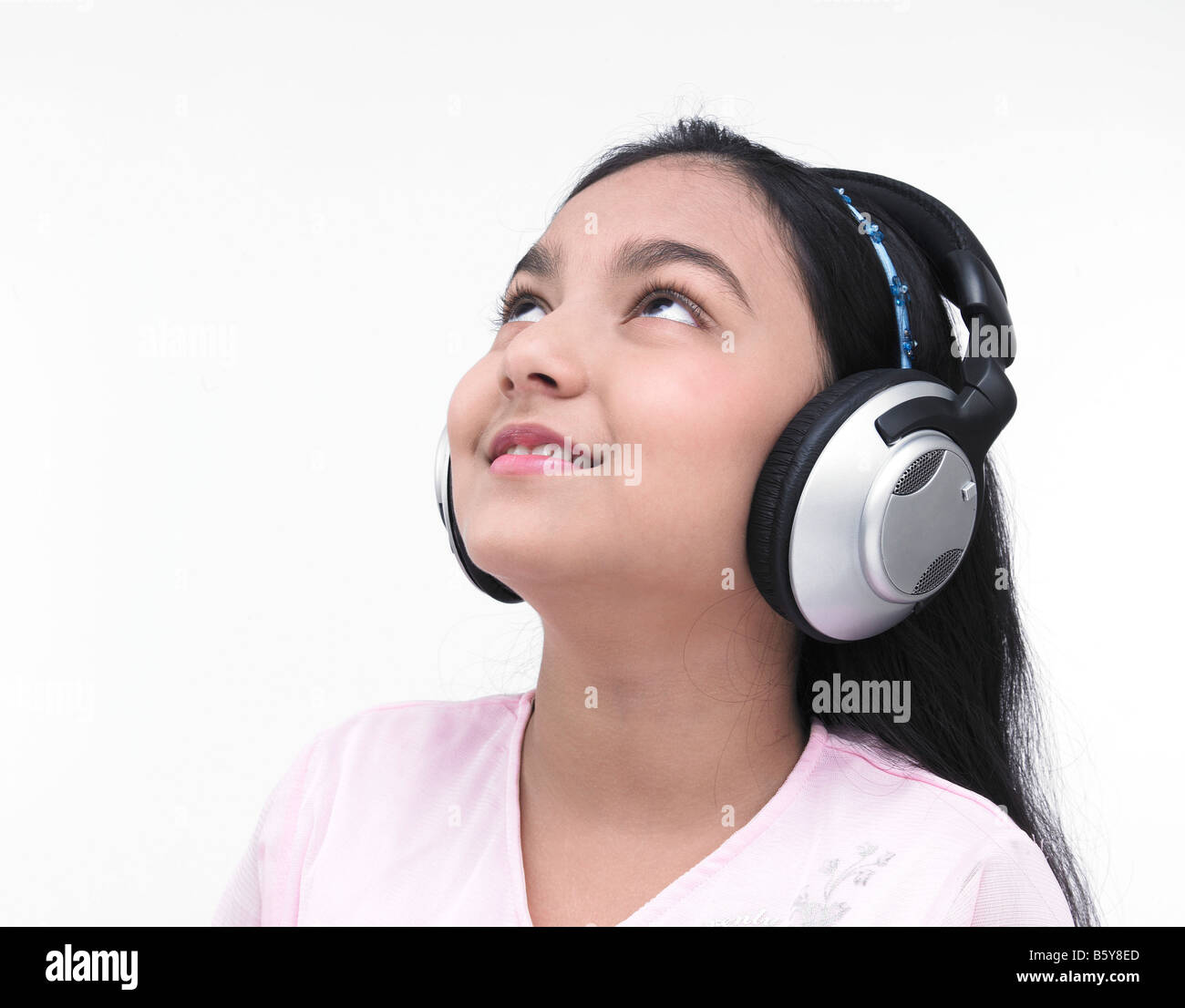 portrait of an asian teenage girl of indian origin listening to music Stock Photo