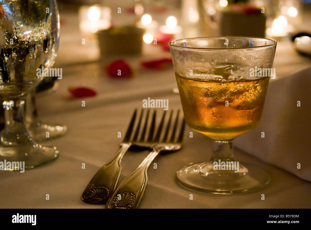 A glass of golden hard liquor on the rocks Could be scotch bourbon or whiskey Stock Photo