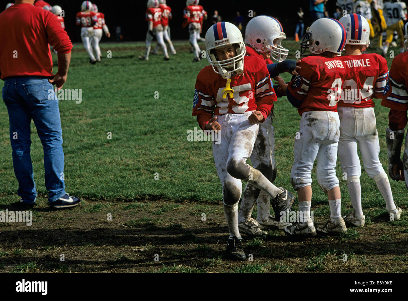 Football team along sidelines during game young boy celebrating ...