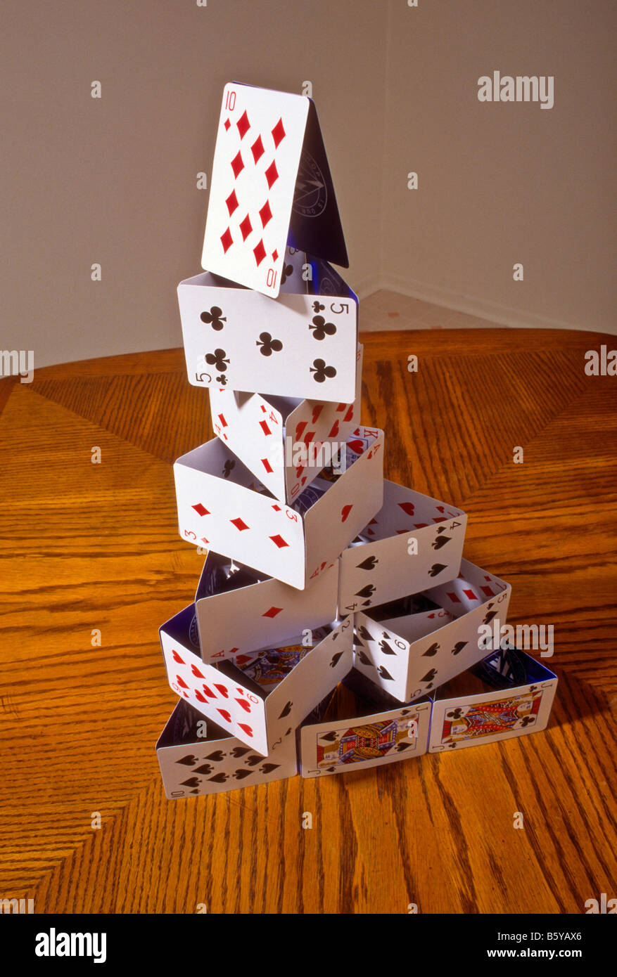 Playing cards stacked into a "house of cards" on table Stock Photo Alamy