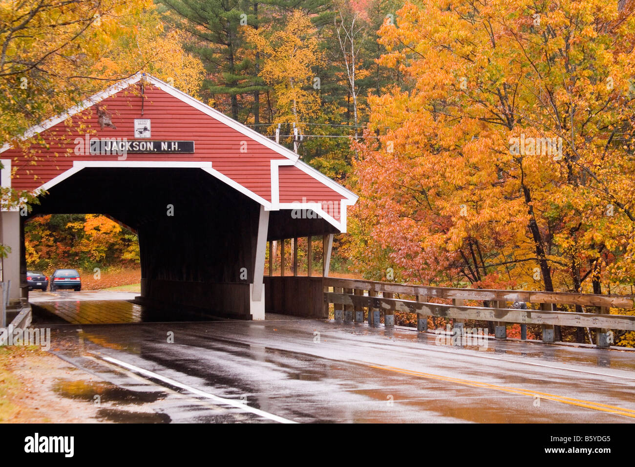 A covered bridge in Jackson, New Hampshire, surrounded by colorful autumn foliage. Stock Photo
