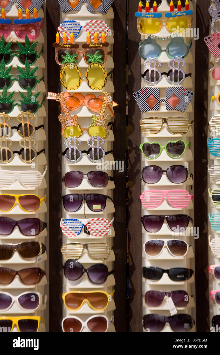 Humourous and colourful sunglasses for sale outside a beach shop. Stock Photo