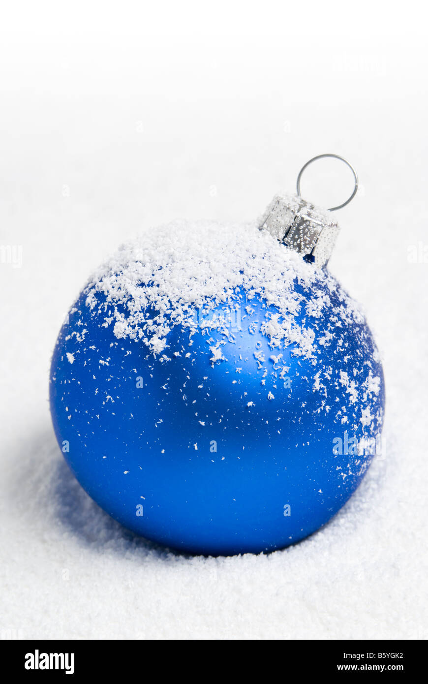 Blue christmas ball lying on the snow. aRGB. Stock Photo