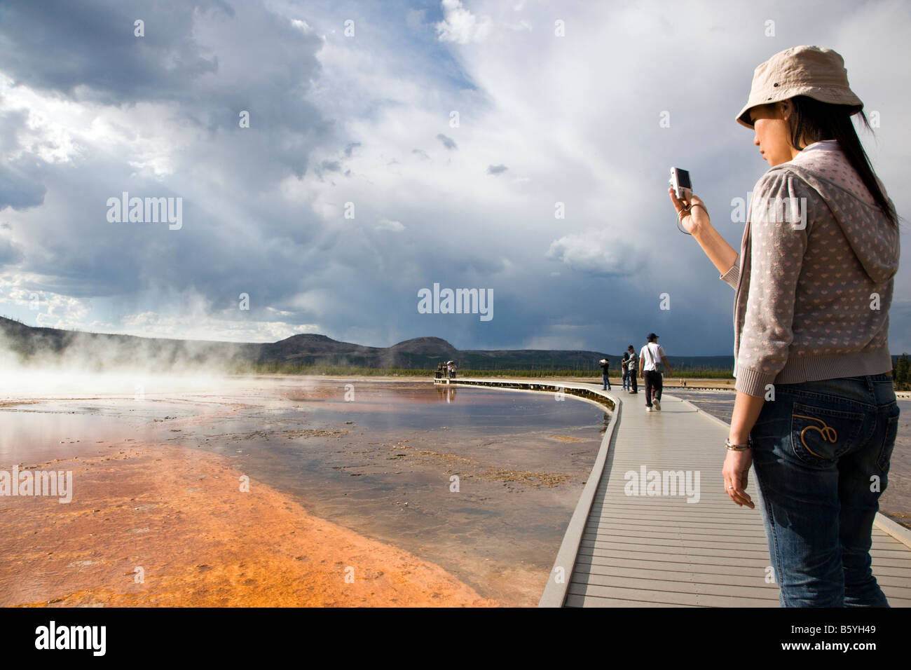Visitor snaps a photo of Grand Primatic Spring, Midway Geyser Basin, Yellowstone National Park, Wyoming, USA Stock Photo