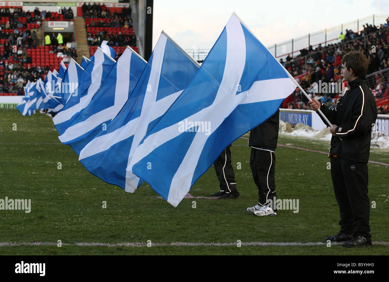 Young flag bearers waving Scottish Saltire flags at a national rugby match at Pittodrie Stadium, Aberdeen, Scotland, uk Stock Photo