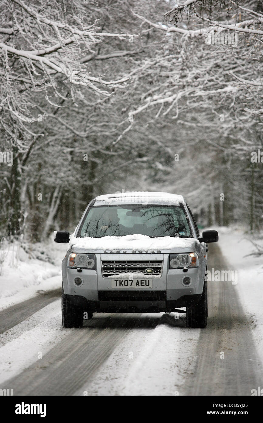 Land Rover Freelander 2 four wheel drive vehicle driving along a snow covered rural road in winter, in Scotland, UK Stock Photo