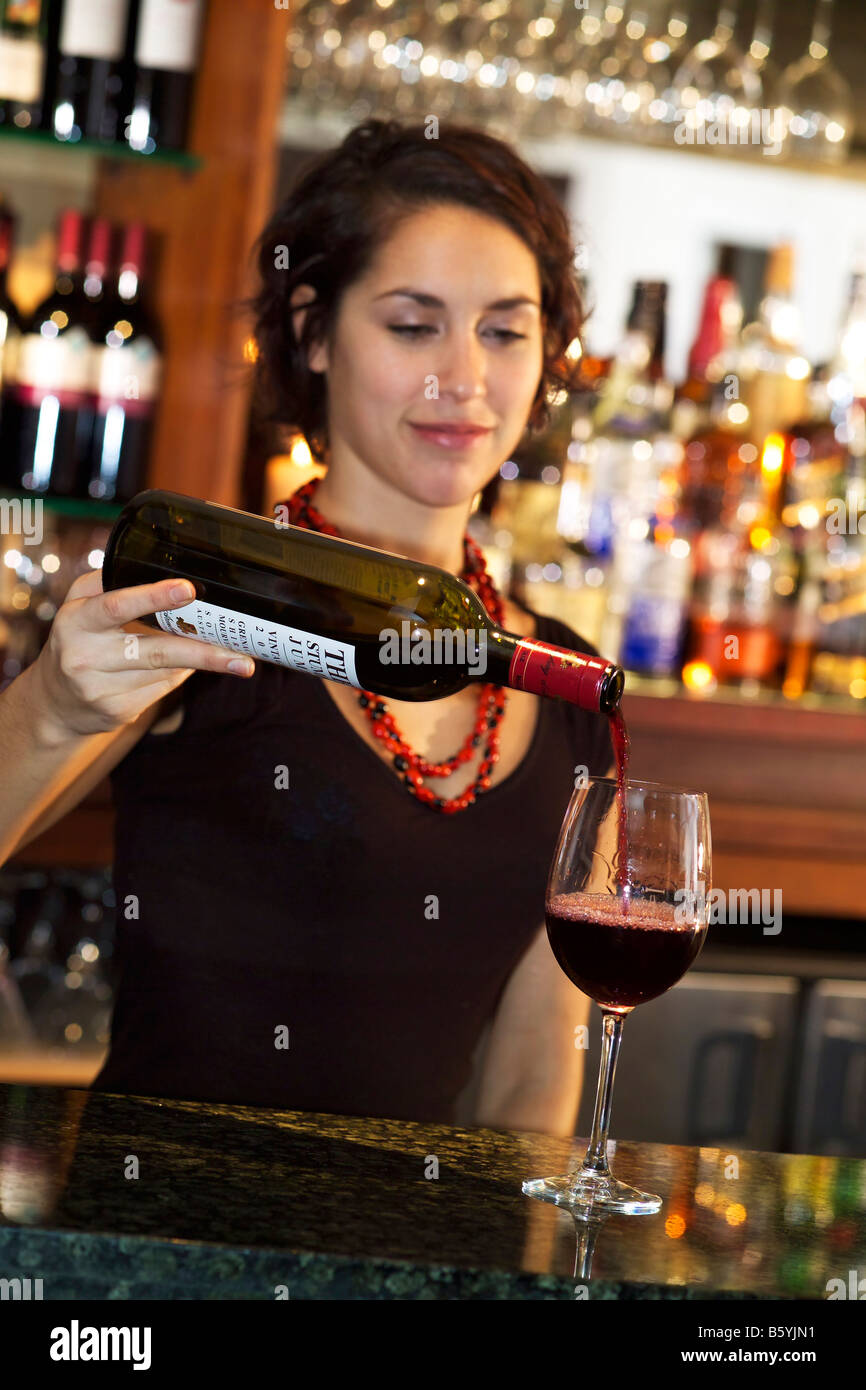 Red wine being poured from bottle into glass Stock Photo Alamy