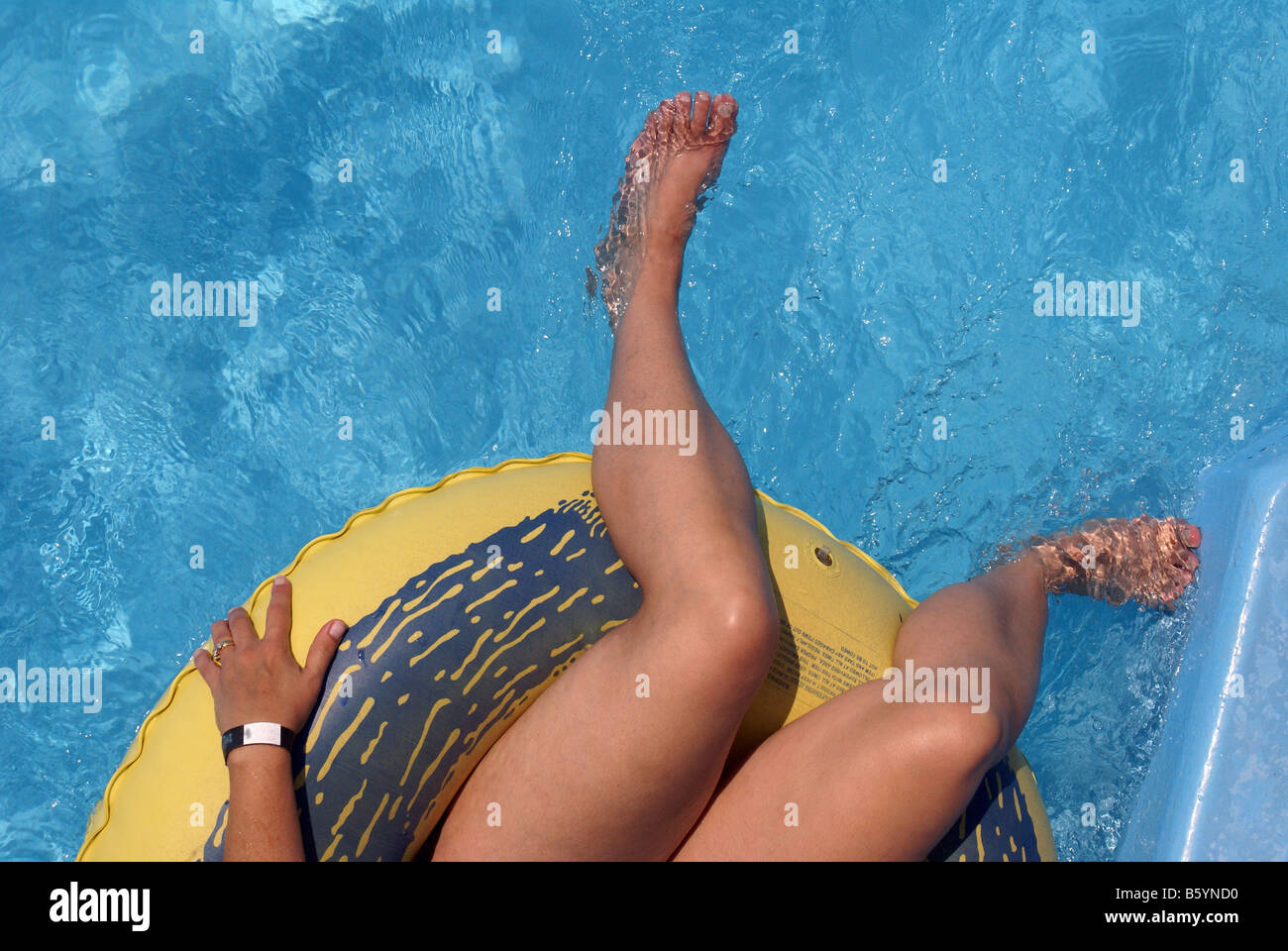 Floating in swimming pool Stock Photo - Alamy