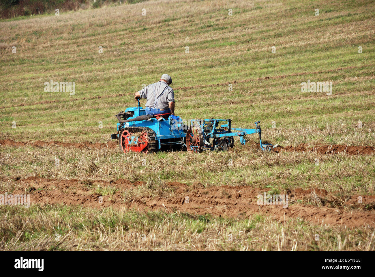 Vintage small sit on tracked tractor and plough by Ransomes of Ipswich at the Surrey County Ploughing Match and Country Fair 200 Stock Photo