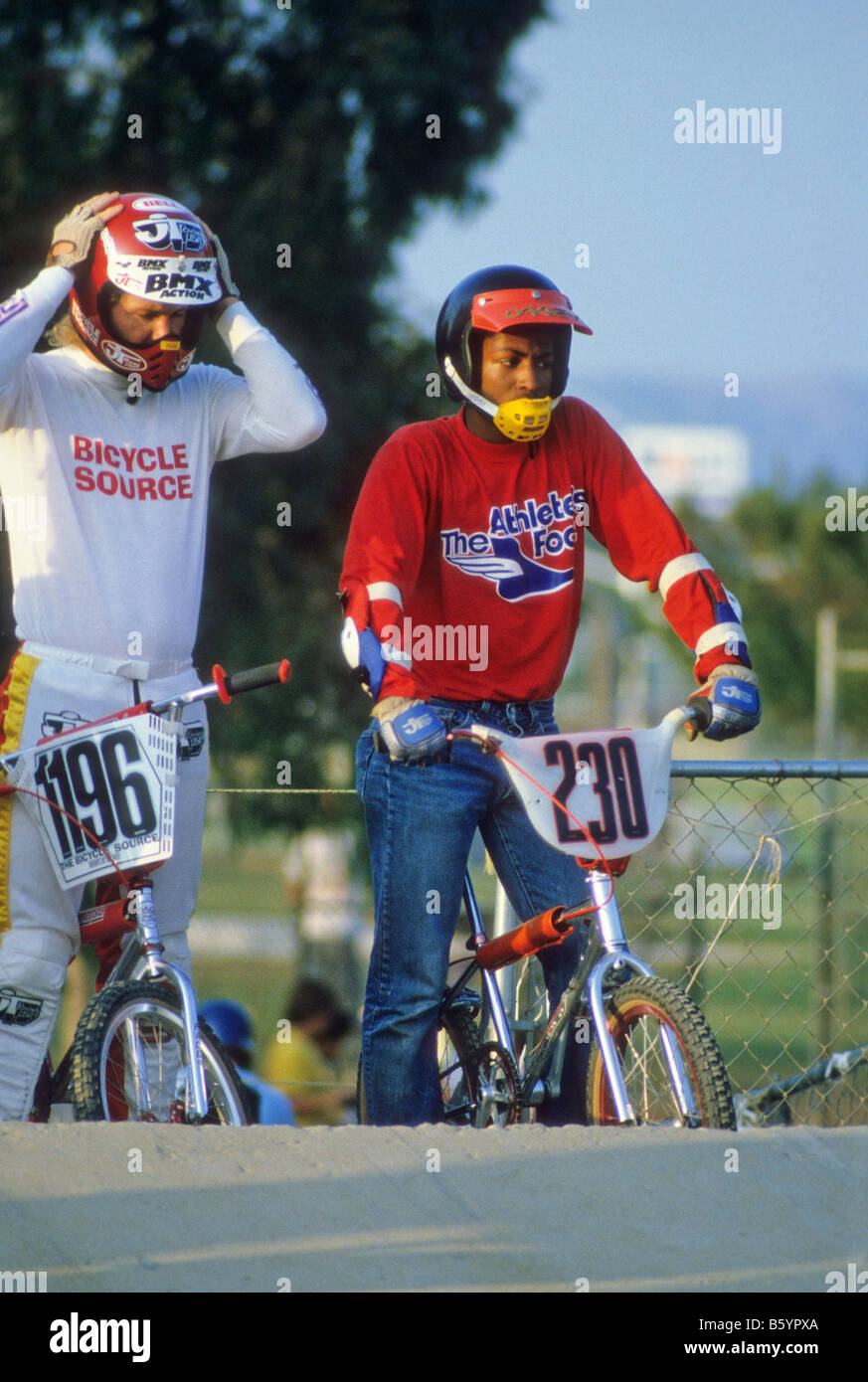 Black boy and white boy get ready to race bicycles at bicycle motocross event. Stock Photo