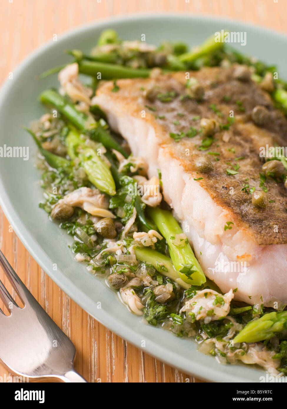 Fillet of Hake with Cockles Green Vegetables and Salsa Verde Stock Photo