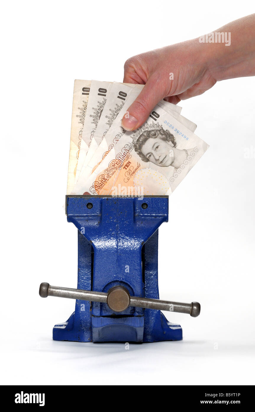 Money clamped in a vice with a hand trying to remove it Stock Photo