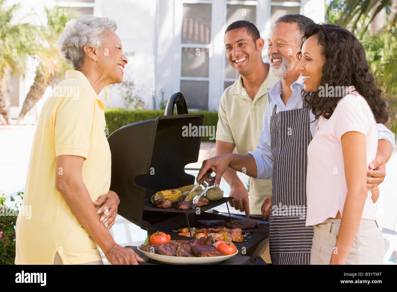Family Enjoying A Barbeque Stock Photo - Alamy