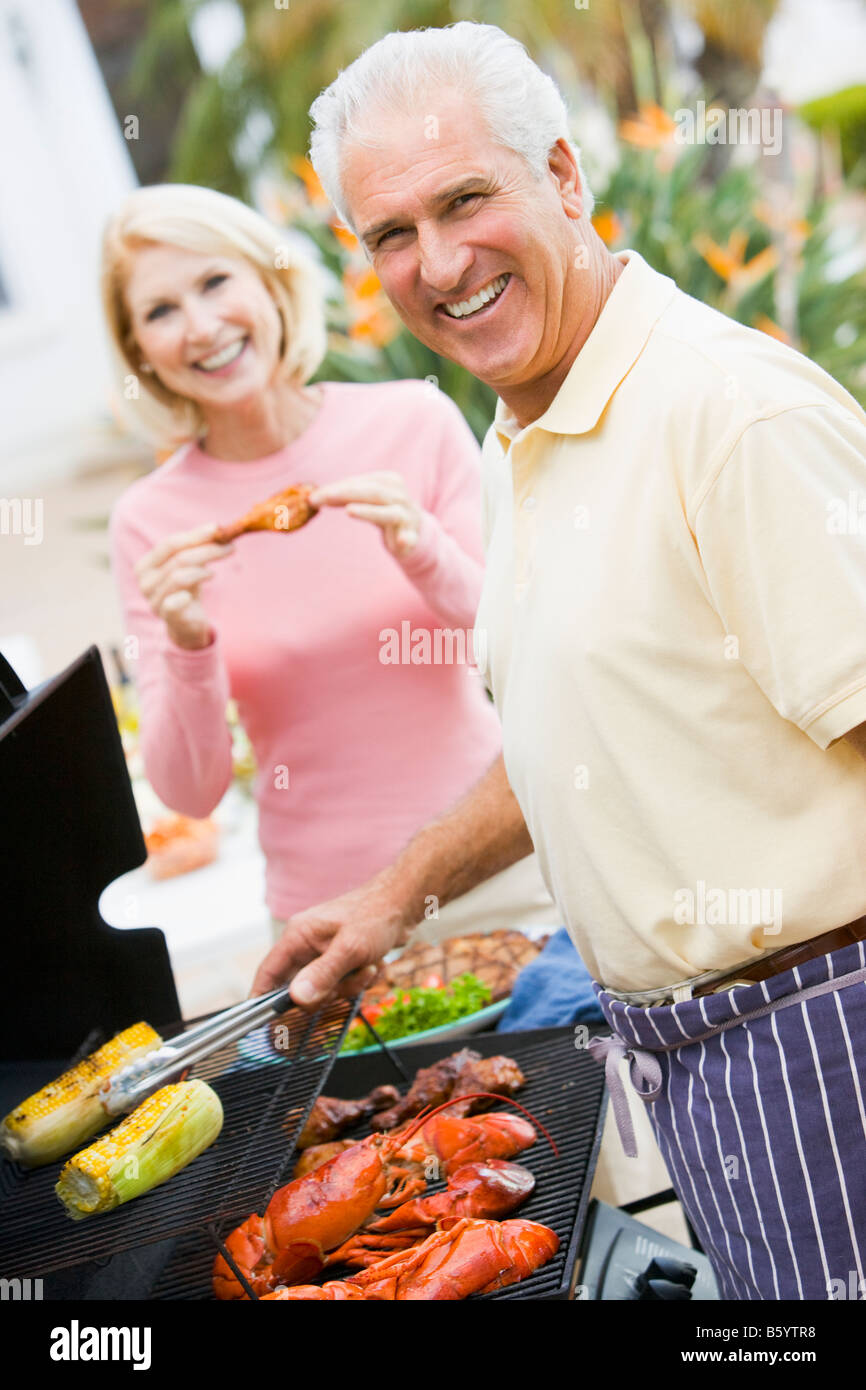 Couple Cooking On A Barbeque Stock Photo