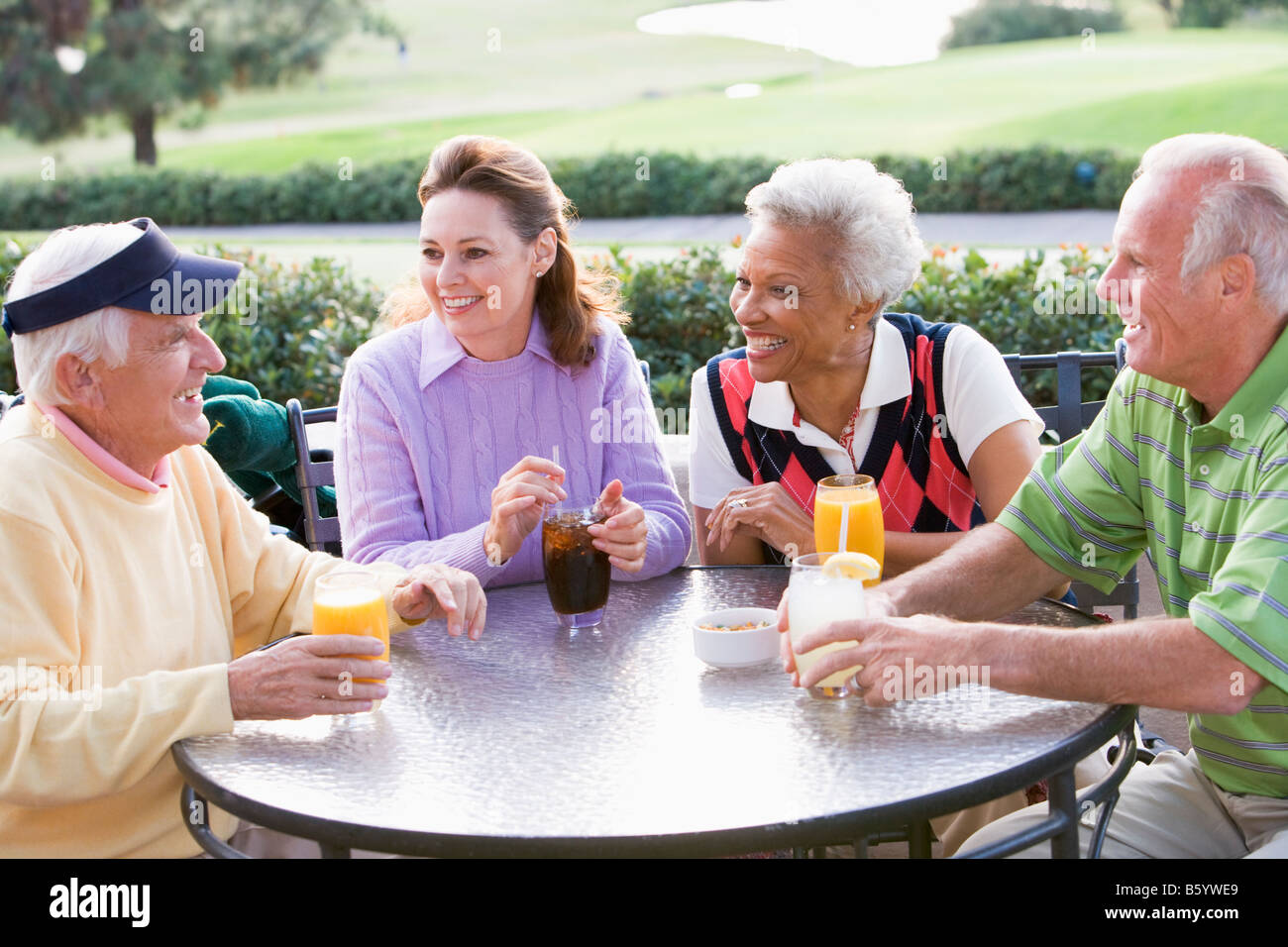 Friends Enjoying A Beverage By A Golf Course Stock Photo